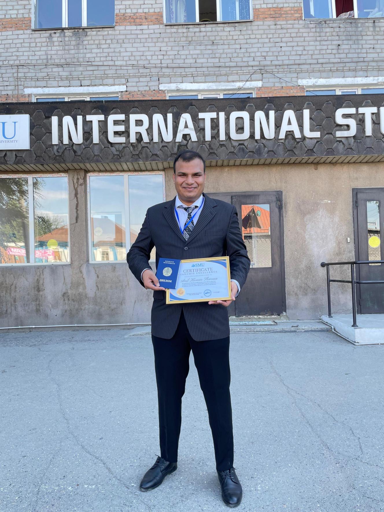 Dr. Anil Sharma holding an academic excellence certificate